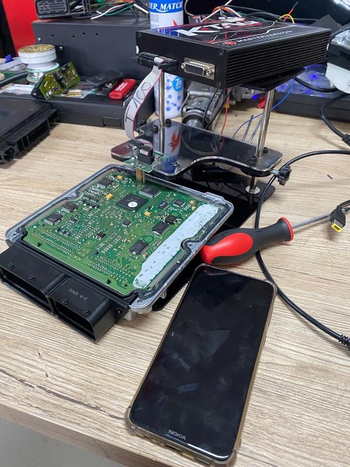 Geöffnetes Steuergerät am Elektronik-Arbeitsplatz, Aufnahme aus einer Anzeige von DM Auto